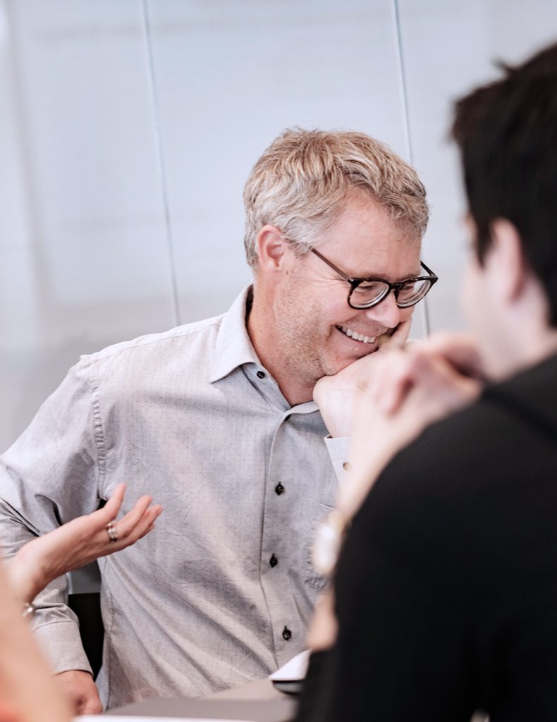 Picture of people laughing at a meeting.