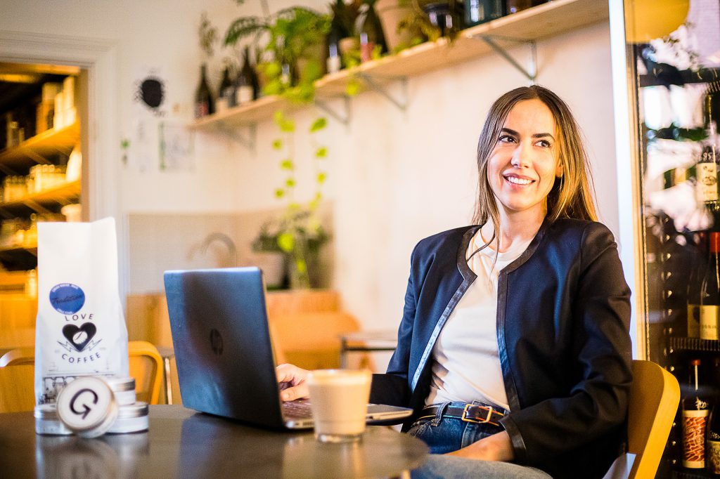 Picture of Irene Atance, sitting at a table with a laptop and a cup of coffee.